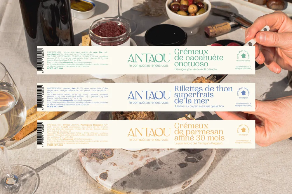 Trois étiquettes allongées posées sur une table d’apéritif : crémeux de cacahuète, rillettes de thon, crémeux de parmesan.