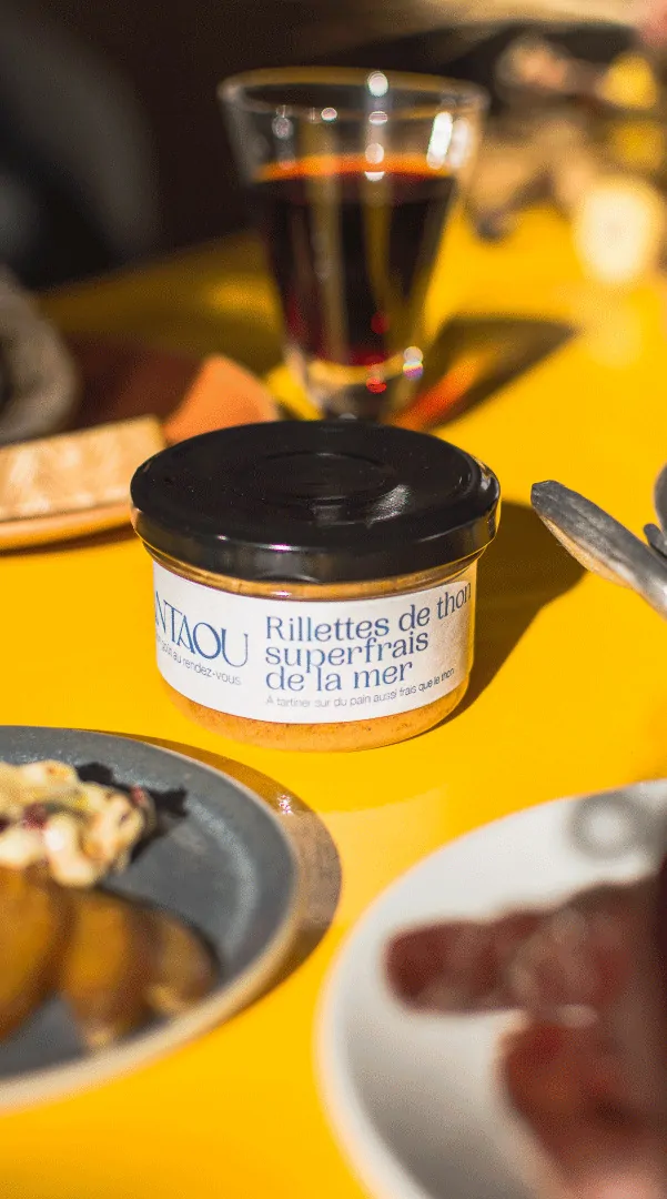 Un pot Antaou et un verre de vin sur un fond jaune.