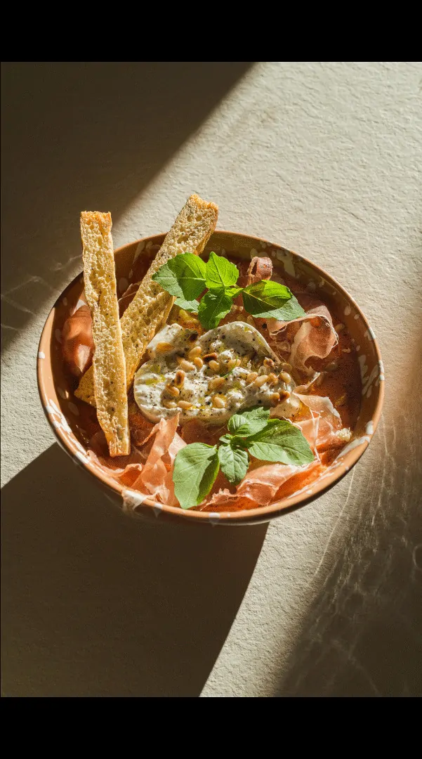 Un bol de salade garnie, éclairé par une lumière rasante.