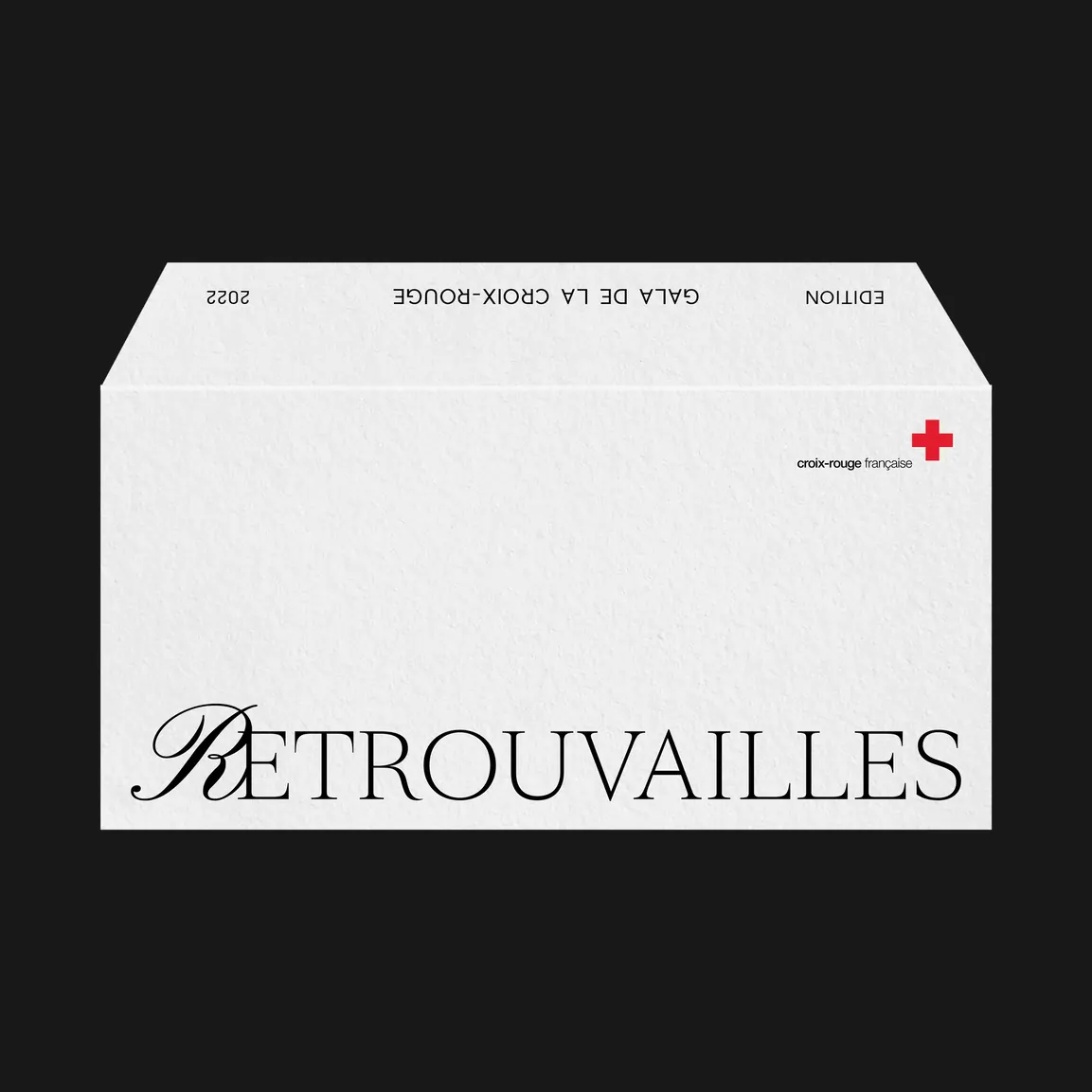 Une enveloppe blanche portant « Retrouvailles » en relief, une croix rouge dans un angle.