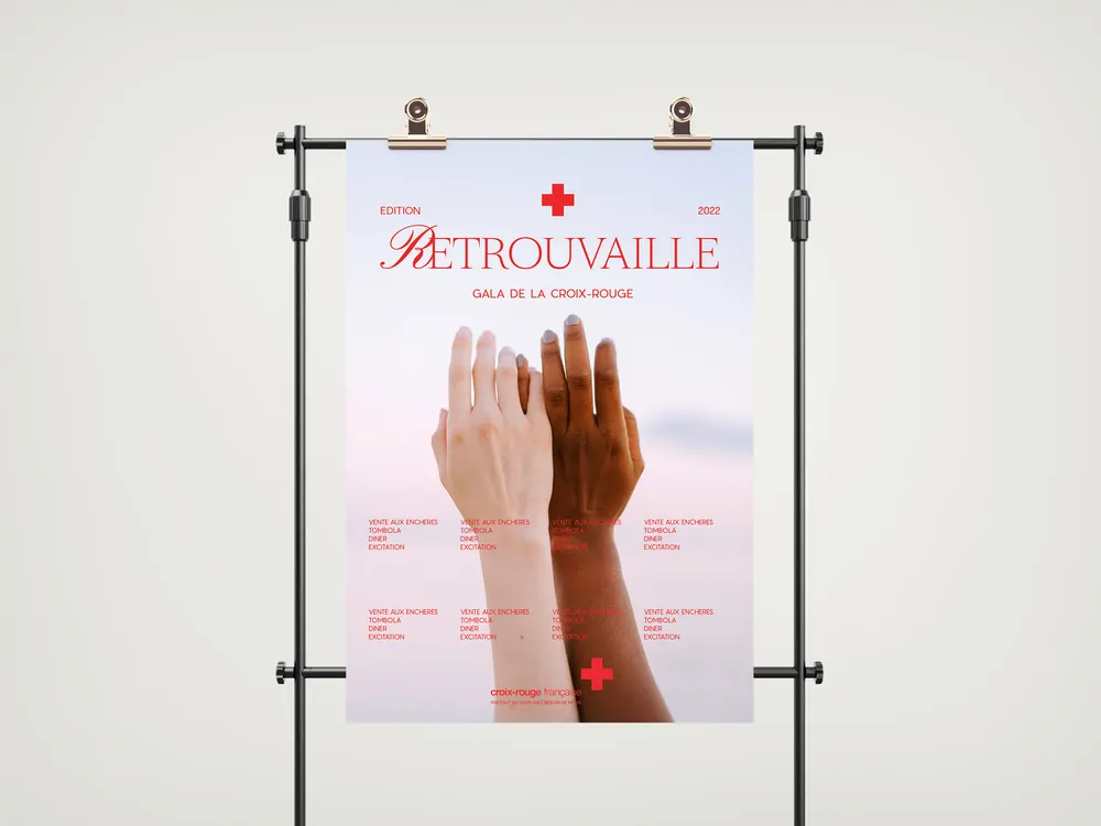 Une affiche suspendue : deux mains, l’une claire et l’autre foncée, se rejoignent sur un ciel rose, avec le mot « Retrouvailles ».