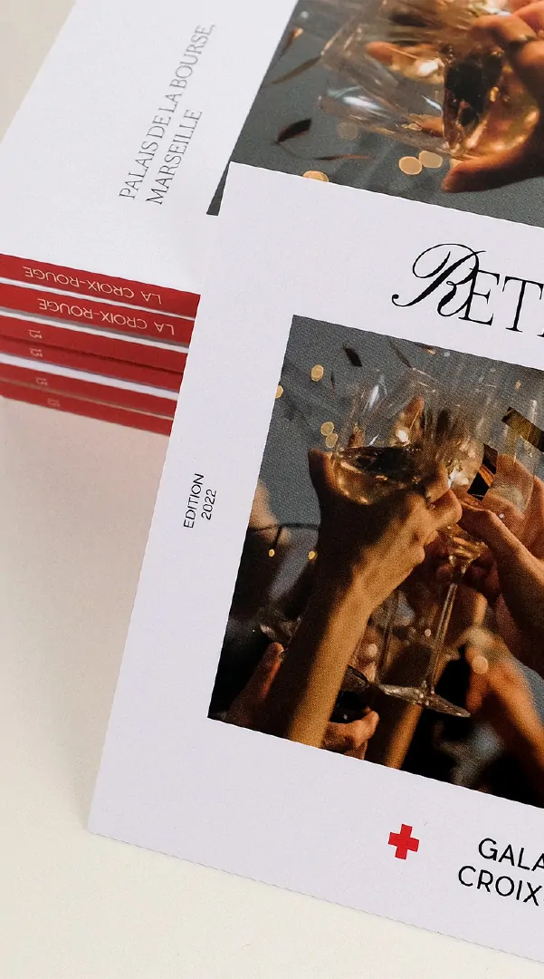 Le bord de la couverture du catalogue, ses bandes rouges et le mot « Retrouvailles ».