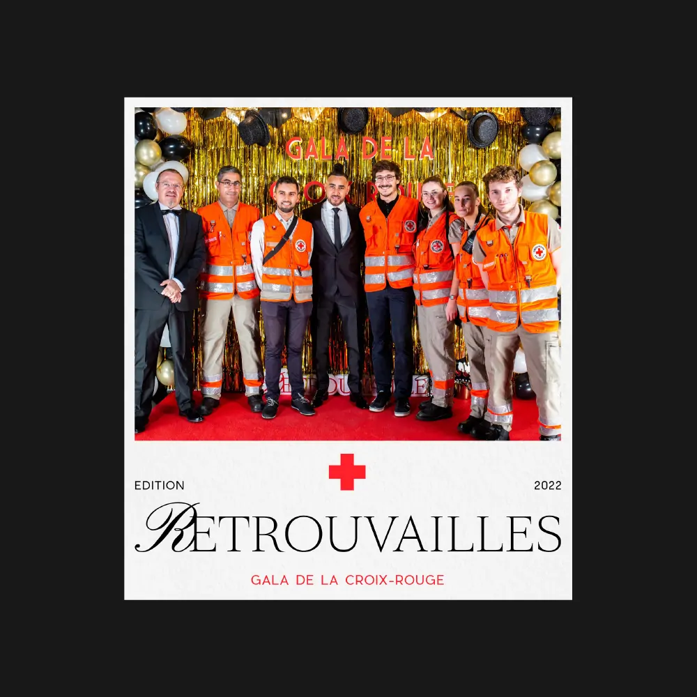 Les bénévoles de la Croix-Rouge en gilets orange, au côté d’invités, devant un rideau doré, sous le mot « Retrouvailles ».
