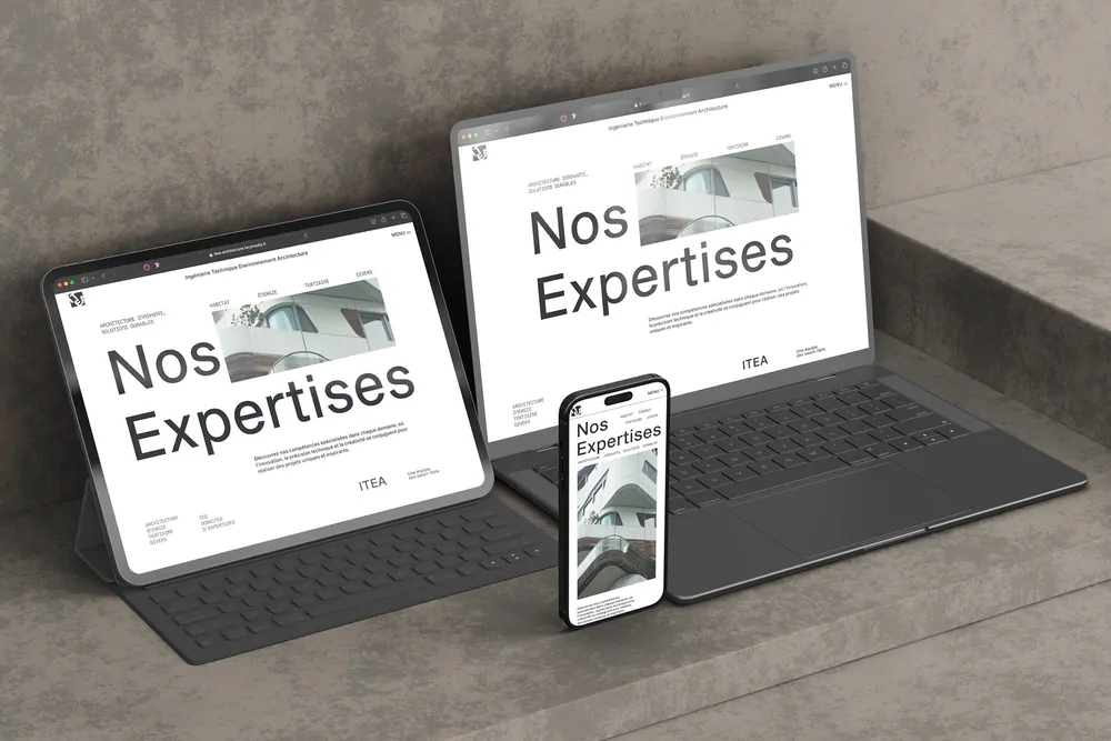Une tablette, un ordinateur et un téléphone affichant la page « Nos expertises » du site d’ITEA, posés sur la pierre.