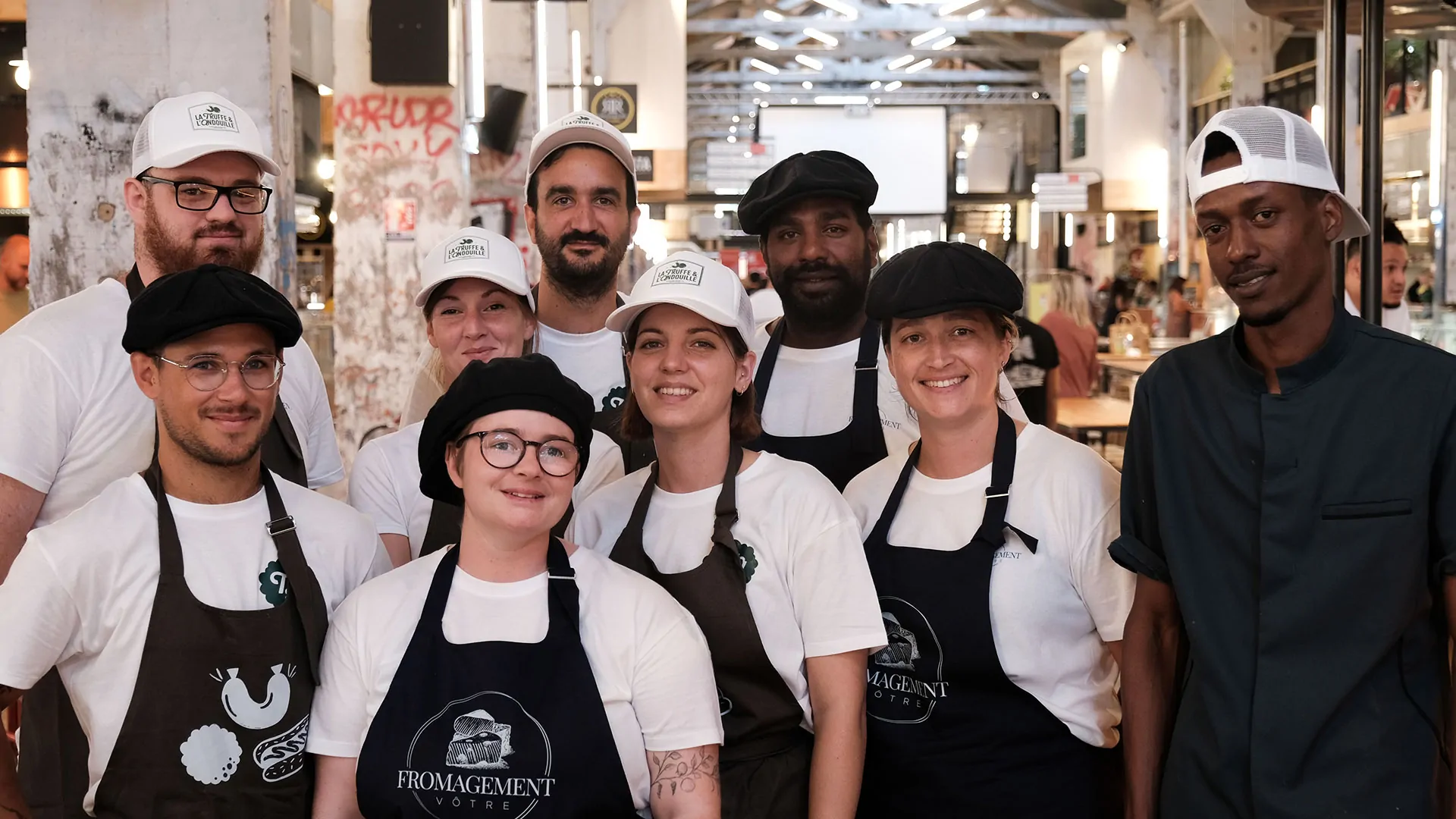 L’équipe, en tee-shirts blancs et tabliers noirs, pose ensemble dans les Halles de la Cartoucherie.