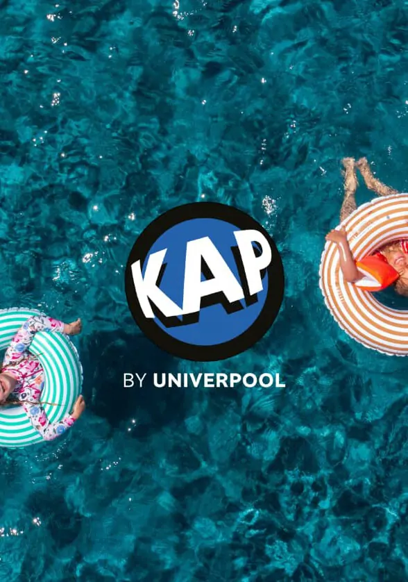 KAP by Univerpool — le logo circulaire sur l’eau d’une piscine vue du ciel, deux enfants sur des bouées