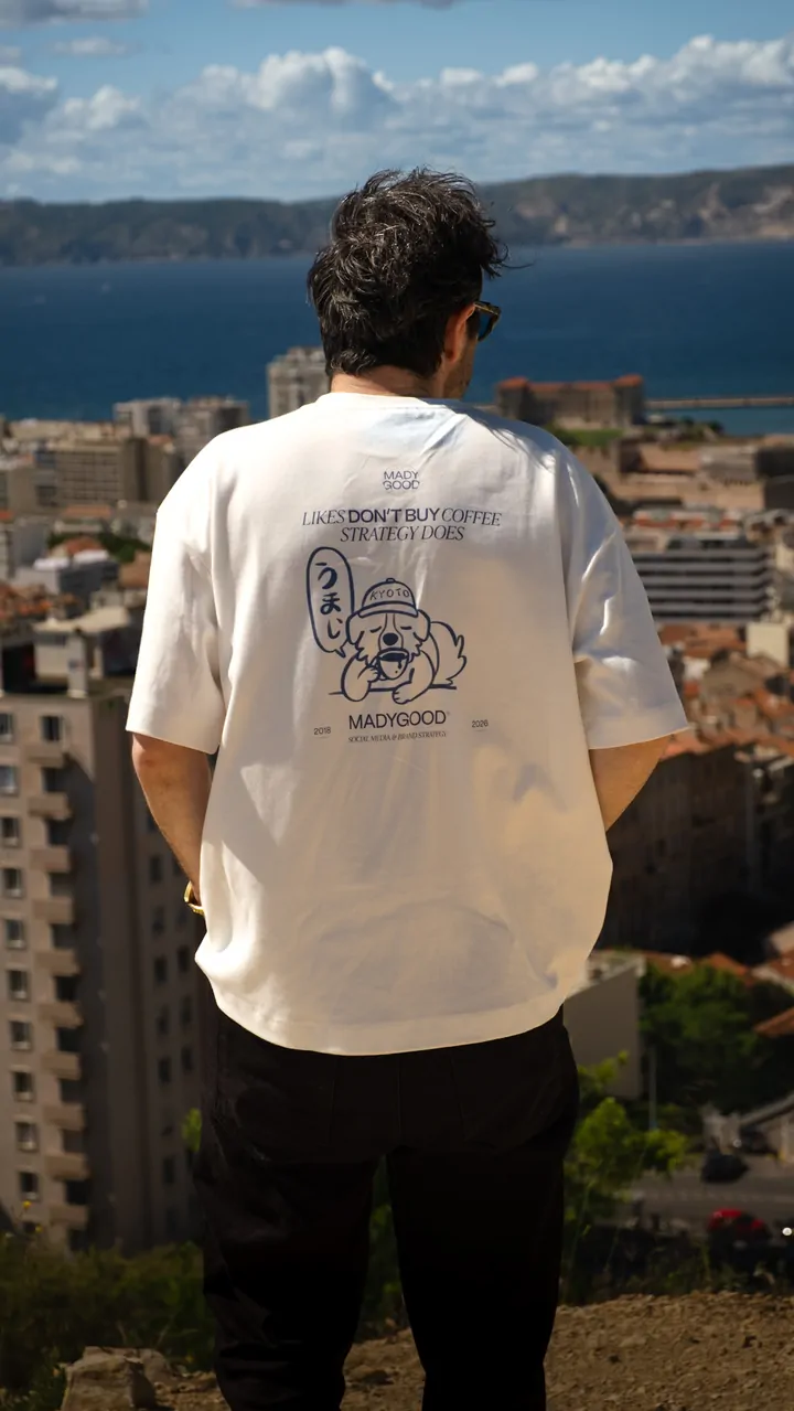 Un homme vu de dos, en tee-shirt écru, face à la baie de Marseille et à la mer.