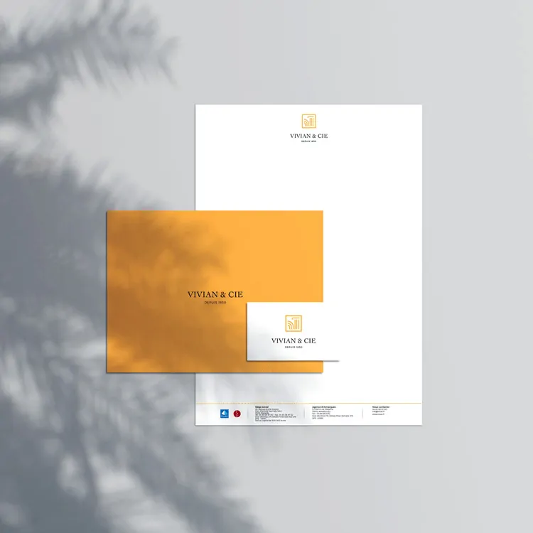 Une feuille à en-tête blanche et une carte jaune posées sur un fond gris.
